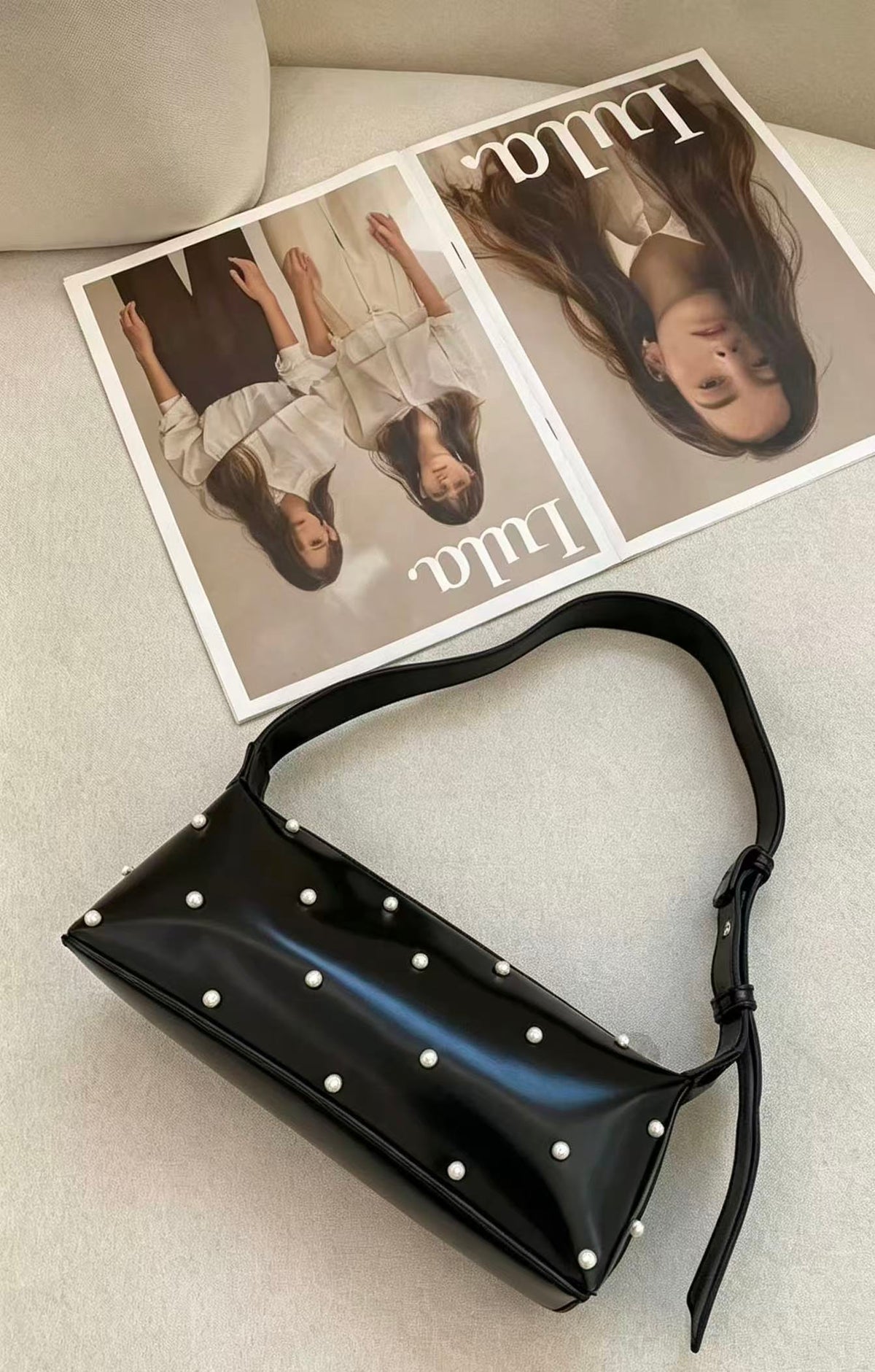 Lunette shoulder bag showing glossy texture and white bead details