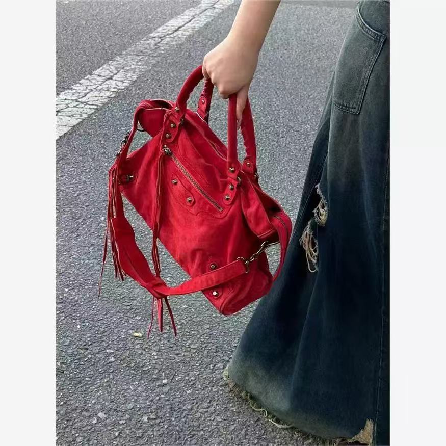 Roxie red satchel showing front zipper pocket and metal accents